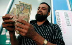 A man counts Sri Lankan rupees in a money exchange in Colombo. On September 29 Sri Lanka’s central bank said it was allowing foreigners to buy into government securities again, a day after the rupee currency appreciated suddenly