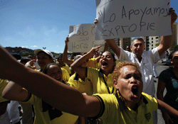 Expropriation threat: employees of the Exito hypermarket in Caracas and supporters of Hugo Chávez express support for the president’s decision to take over the chain