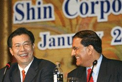 Shin Corporation executive chairman Boonklee Plangsiri, left, and Temasek's managing director of investments, S Iswaran