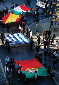 Protesters carry flags of Portugal, Greece, Spain and Italy as they march through Athens during an anti-austerity rally in November